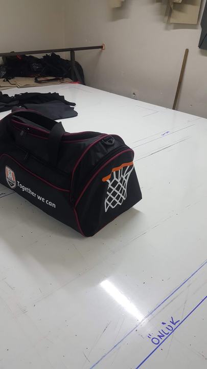 Kesim masasında işaretli kumaşın yanında spor çanta